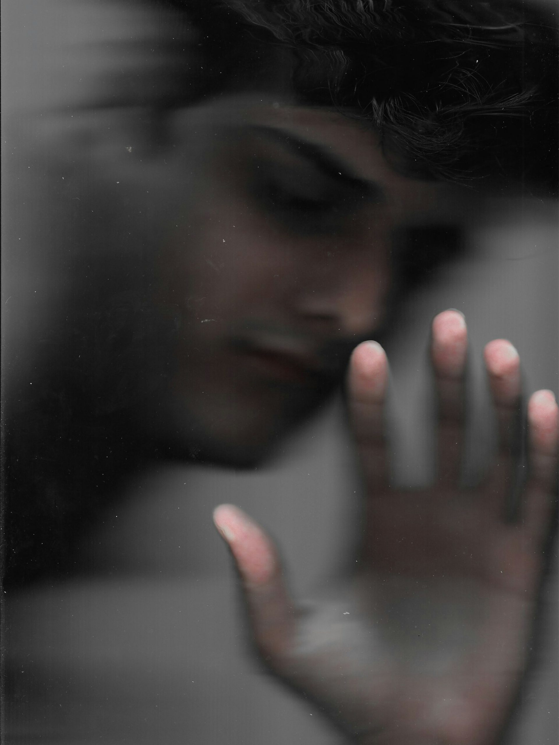 Blurred image of man with hand against window